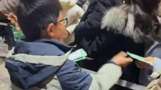 9岁男孩给排队买“广德三件套”的游客免费发暖宝宝