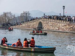 第一批游客已抵达西湖边，羽绒衣、毛衣、T恤、背心齐飞