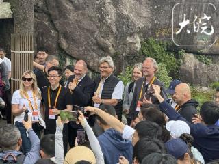 世界市长对话黄山之巅：穿外骨骼登顶，在云海间畅聊城市未来