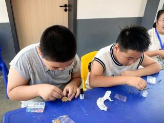 济宁市任城区长沟镇小手牵银发服务站“七彩暑托班”组织开展非遗螺钿手工制作活动